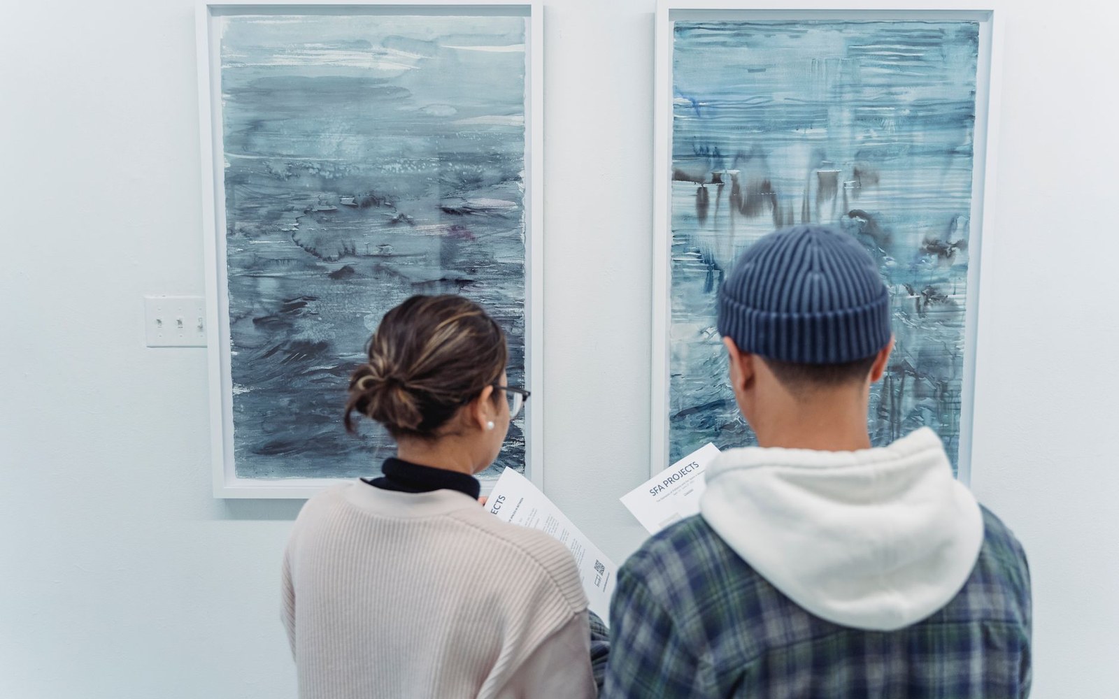 Two adults standing well back from a very large canvas